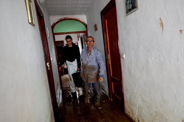 سكان يزيلون الوحل من أحد المنازل عقب الفيضانات الناجمة عن الأمطار الغزيرة في بلدة إلس بوبلتس بمقاطعة أليكانتي شرقي إسبانيا. - سبوتنيك عربي