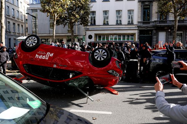 متظاهرون يقلبون سيارة خلال احتجاج طلابي في بروكسل، بلجيكا. - سبوتنيك عربي