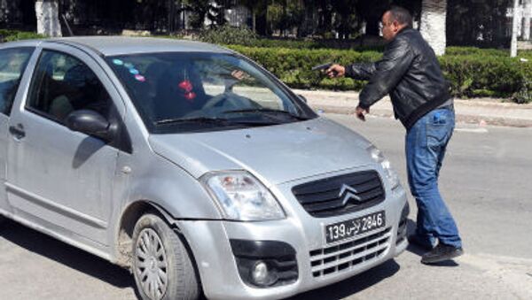 شرطي في لباس مدني يوقف سيارة في مكان حادثة الهجوم الارهابي في تونس - سبوتنيك عربي