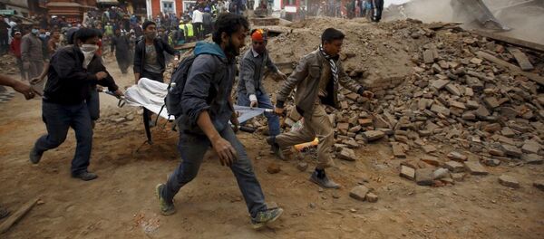 الناس يحملون على نقالةأحد ضحايا الزلزال - سبوتنيك عربي