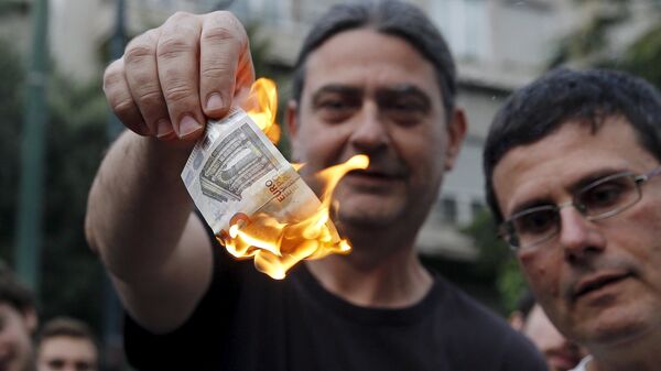 متظاهر يوناني يحرق عملة اليورو خلال مسيرة إحتجاجية ضد الإتحاد الأوروبي فى أثينا - سبوتنيك عربي