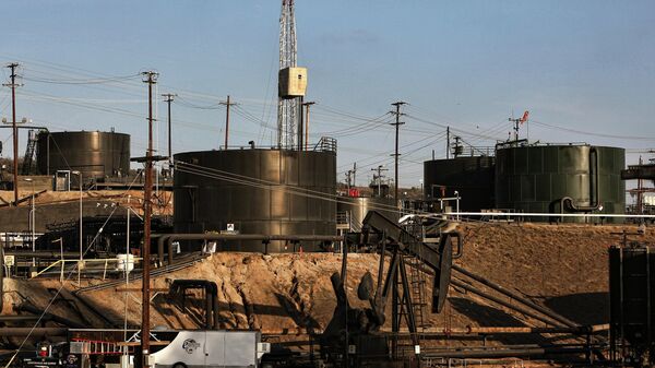 This Thursday March 6, 2014 photo shows pumpjacks operating in front of a hydraulic fracturing site in the Inglewood oil fields in the Baldwin Hills area of Los Angeles - سبوتنيك عربي