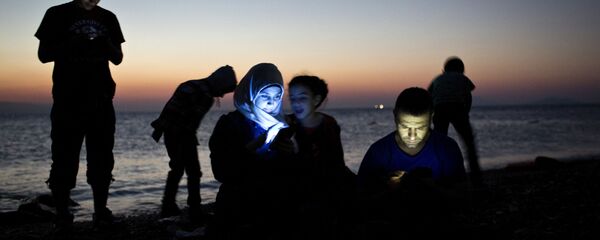 مهاجرين يتفقدون هواتفهم على اليابسة في جزيرة كوس اليونانية بعد رحلة طويلة في قوارب مطاطية مهاجرين يتفقدون هواتفهم على اليابسة في جزيرة كوس اليونانية بعد رحلة طويلة في قوارب مطاطية - سبوتنيك عربي