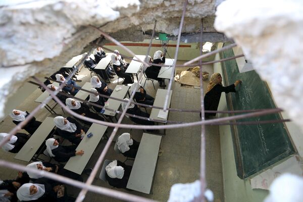 ثقب كبير، خلفته قذيفة، في سقف أحد الصفوف، في إحدى مدارس غزة للبنات - سبوتنيك عربي