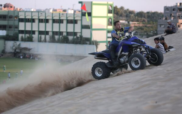 شاب فلسطيني أثناء قيادته للدراجة الرباعية في مدينة غزة. - سبوتنيك عربي