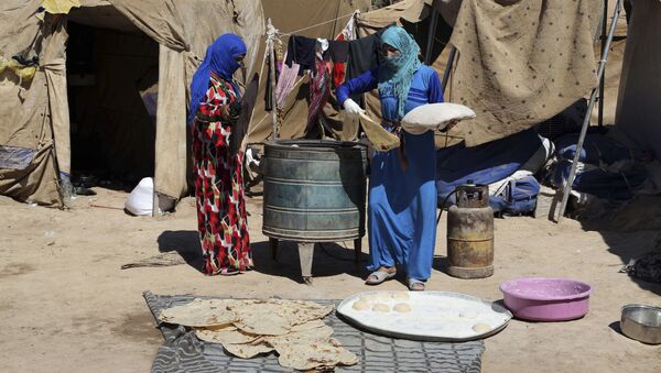 Iraqi women bake bread at al-Takia refugee camp in Baghdad, Iraq, Thursday, Sept. 24, 2015 - سبوتنيك عربي