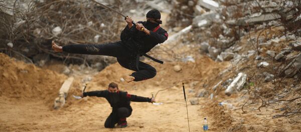 شاب فلسطيني يقفز حاملاً سيفه، مقدماً بذلك مهارات النينجا، من أمام المباني المدمرة إثر الحرب الأخيرة 2014، شمال قطاع غزة، 29 يناير/ كانون الثاني 2016. - سبوتنيك عربي