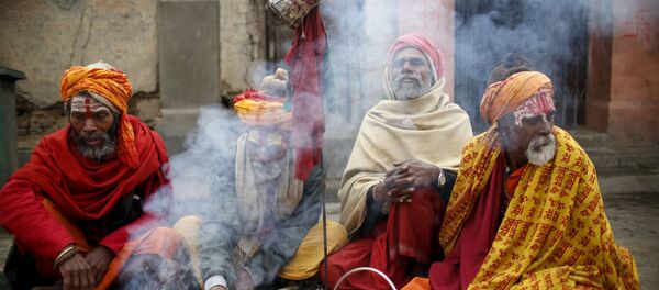 الهنديون المقدسون، أو رجال سادهو، يجلسون القرفصاء أمام النار في معبد باشوباتيني في كاذاماندو بنيبال، 6 مارس/ آذار 2016. - سبوتنيك عربي
