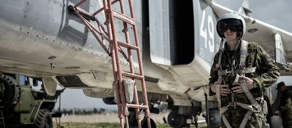 طيار القوات الجوية-الفضائية الروسية بجوار المقاتلة سو-24 في القاعدة الجوية السورية حميميم. - سبوتنيك عربي