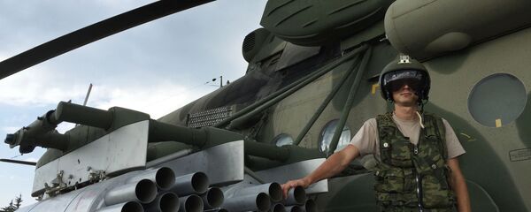 طيار القوات الجوية-الفضائية الروسية بجوار المروحية مي-8 أ/م/ش/ت في مطار القاعدة الجوية السورية حميميم. - سبوتنيك عربي