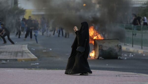 امرأة تلتقط صورة للاشتباكات والتصادمات بين الشرطة والمتظاهرين في البحرين، 5 ابريل/ نيسان 2016. - سبوتنيك عربي