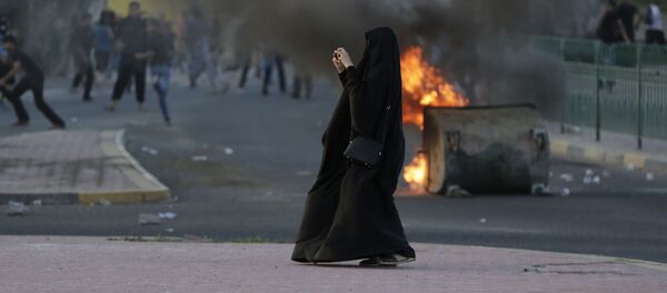 امرأة تلتقط صورة للاشتباكات والتصادمات بين الشرطة والمتظاهرين في البحرين، 5 ابريل/ نيسان 2016. - سبوتنيك عربي