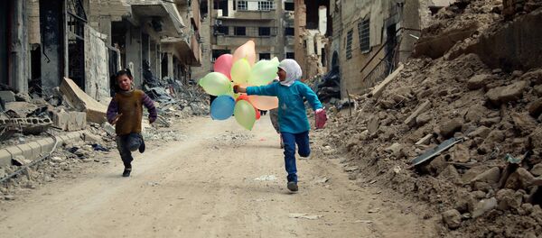 أطفال يلعبون بين دمار الحرب بالضواحي الشرقية للعاصمة السورية دمشق، 9 أبريل/ نيسان 2016 - سبوتنيك عربي