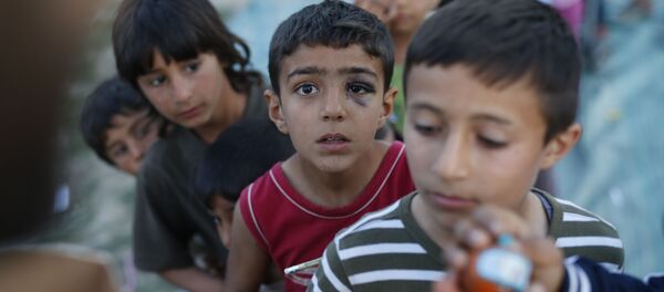 الأطفال المهاجرون يقفون في طابور للحصول على الألعاب في مخيم للاجئين باليونان، 17 أبريل/ نيسان 2016. - سبوتنيك عربي