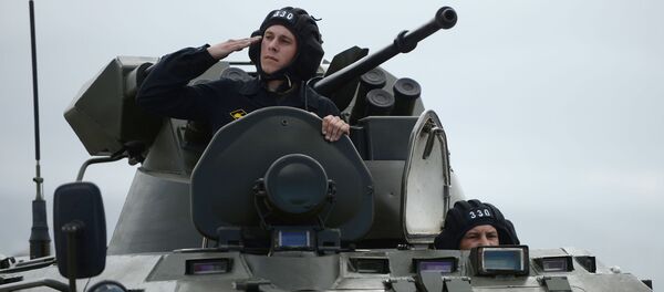 جندي يطل من المدرعة العسكرية ب.ت.ار-82أ خلال البروفة العامة للعرض العسكري بمناسبة إحياء الذكرى الـ 71 لعيد النصر، في القاعدة العسكرية حميميم في سوريا. - سبوتنيك عربي