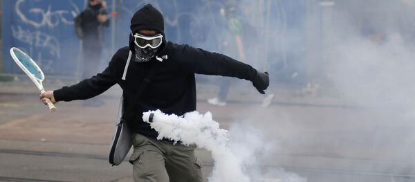 التنس - متظاهر يقوم بضربة تنس لقنبلة غازية مسيّلة للدموع في نانت، فرنسا 2 يونيو/ حزيران 2016. - سبوتنيك عربي