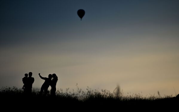 الزوار يأخذون صورة سيلفي على خلفية المنطاد في فيليكي لوكي - سبوتنيك عربي