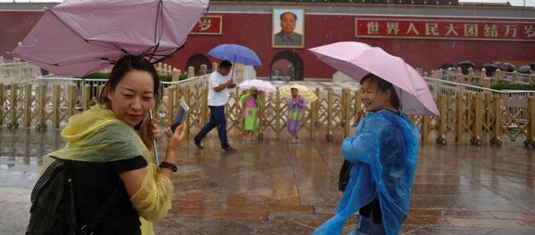 السياح تحت أمطار بكين الغزيرة، الصين 20 يوليو/ تموز 2016 - سبوتنيك عربي