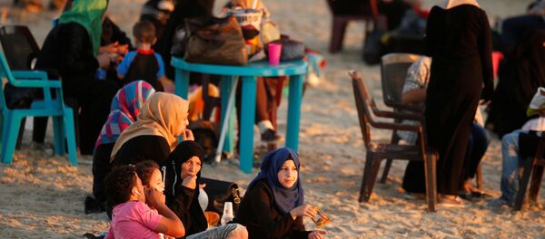 عائلة فلسطينية على شاطئ البحر في مدينة غزة، 19 يوليو/ تموز 2016 - سبوتنيك عربي
