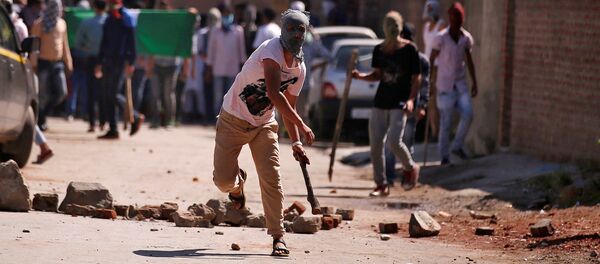 محتج يرمي حجراً خلال احتجاجات ضد القتل في كشمير  في سينغافورة ، 28 يوليو/ تموز 2016 - سبوتنيك عربي
