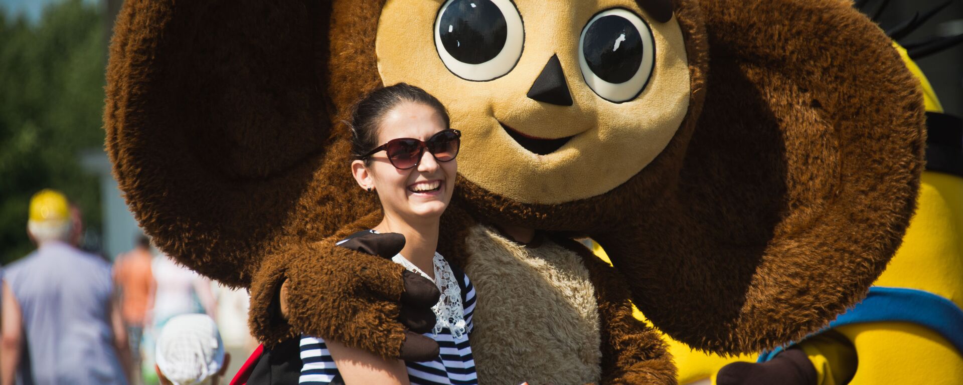 المواطنون والسياح يلتقطون صورا مع دمية كبيرة لإحدى شخصيات فيلم كرتون روسي تشيبوراشكا في حديقة مركز معارض عموم روسيا في موسكو - سبوتنيك عربي, 1920, 20.08.2021