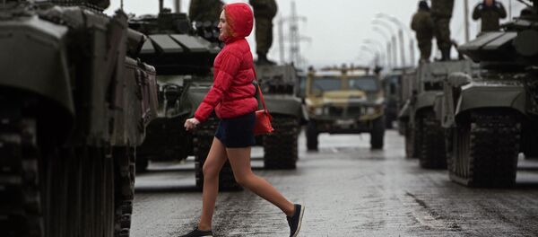 مرور إحدى الفتيات بجانب الدبابات الروسية - سبوتنيك عربي