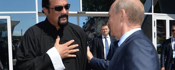 الرئيس الروسي فلاديمير بوتين مع الممثل الأمريكي ستيفن سيغال - سبوتنيك عربي