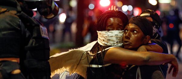 عناق امرأتان أمام الشرطة خلال احتجاجات في مدينة شارلوت الأمريكية عناق امرأتان أمام الشرطة خلال احتجاجات في مدينة شارلوت الأمريكية - سبوتنيك عربي