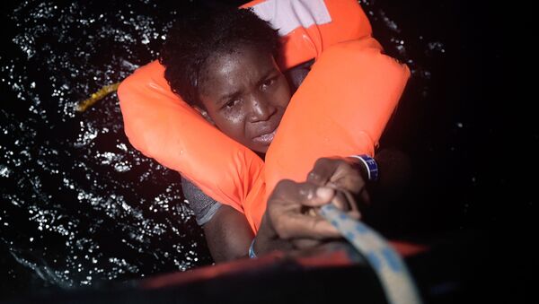 فتاة تمسك بالحبل خلال عملية إنقاذ المهاجرين قبالة السواحل الليبية، 12 أكتوبر/ تشرين الأول 2016 - سبوتنيك عربي