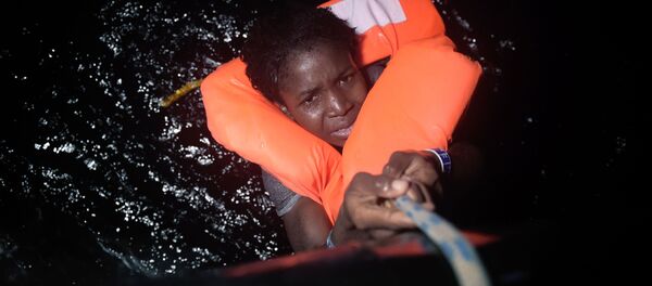 فتاة تمسك بالحبل خلال عملية إنقاذ المهاجرين قبالة السواحل الليبية، 12 أكتوبر/ تشرين الأول 2016 - سبوتنيك عربي