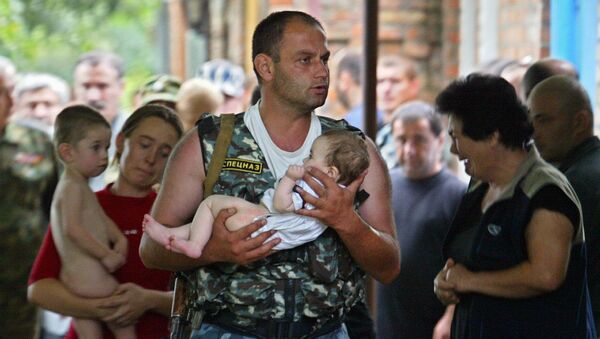 جندي من وحدة القوات الخاصة الروسي يحمل طفلاً، كان رهينة بمدرسة في بيسلان، أوسيتيا الشمالية - سبوتنيك عربي