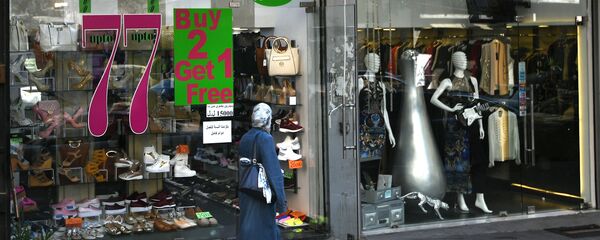 امرأة تسير بجوار محل تجاري في مدينة بيروت - سبوتنيك عربي