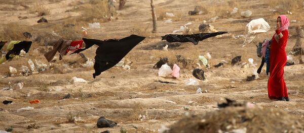 امرأة لاجئة عراقية تعلق الغسيل في مخيم للاجئين التابع للأمم المتحدة بالقرب من الموصل، 31 أكتوبر/ تشرين الأول 2016 - سبوتنيك عربي