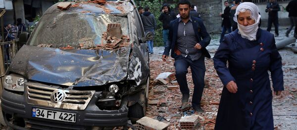 المواطنون يمرون بجوار أثار التفجيرات التي وقعت في ديار بكر، تركيا 4 نوفمبر/ تشرين الثاني 2016 - سبوتنيك عربي