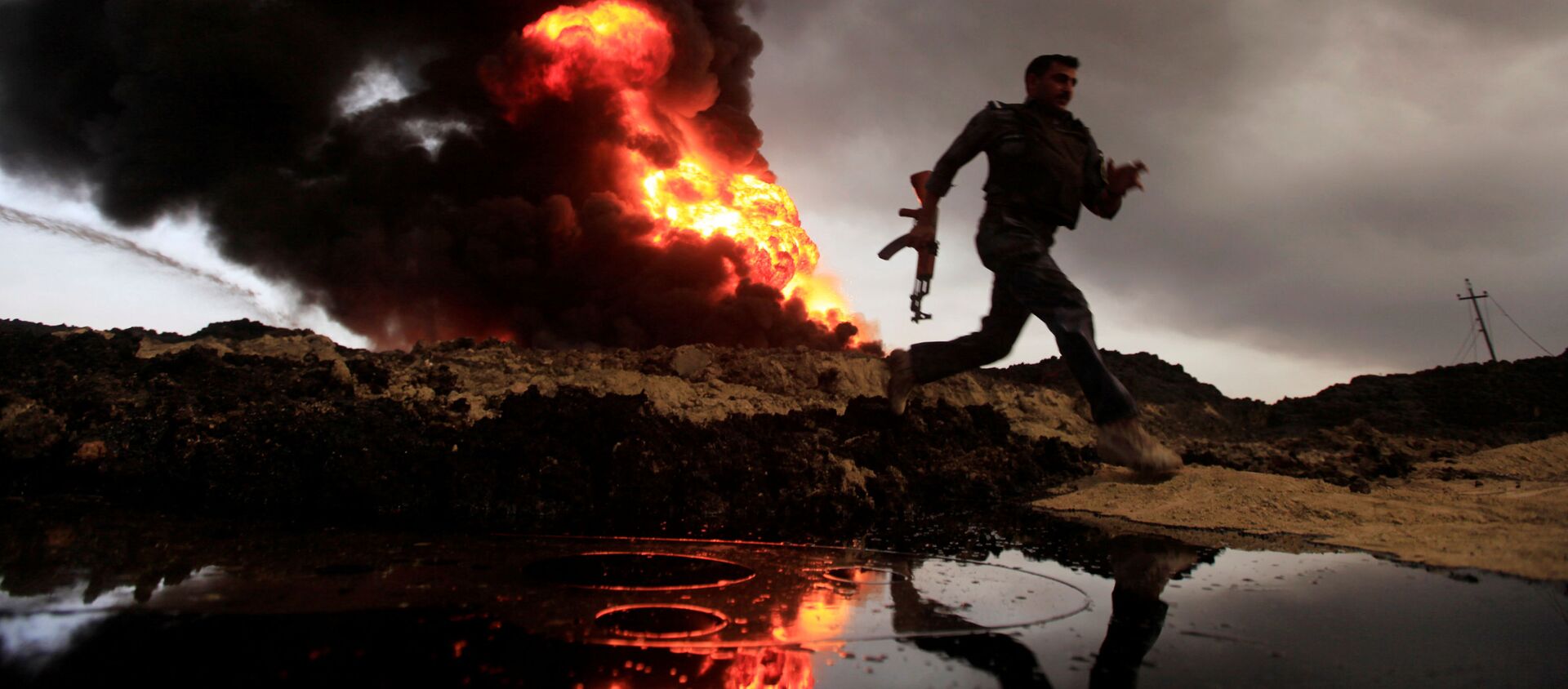 ألسنة اللهب والدخان يتصاعد من آبار النفط التي أشعل فيها النار مسلحي تنظيم داعش قبل فرارهم من المنطقة المنتجة للنفط القيارة، العراق 4 نوفمبر/ تشرين الثاني 2016. - سبوتنيك عربي, 1920, 05.05.2021