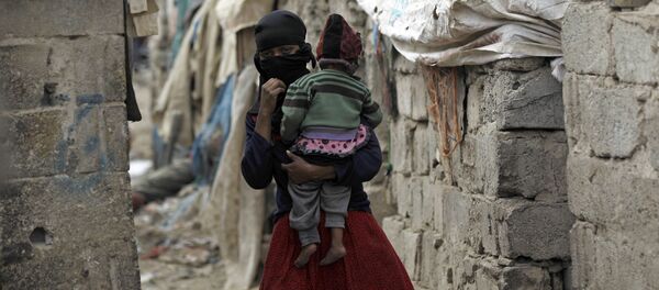 امرأة تحمل طفلها، من مجتمع الخدام، تسير وسط أحد الأحياء الفقيرة في العاصمة صنعاء، اليمن 9 نوفمبر/ تشرين الثاني 2016 امرأة تحمل طفلها، من مجتمع الخدام، تسير وسط أحد الأحياء الفقيرة في العاصمة صنعاء، اليمن 9 نوفمبر/ تشرين الثاني 2016 - سبوتنيك عربي