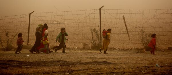 أطفال سوريون يسيرون حول مخيم للنازحين في قرية عين عيسى، والذي فروا من بطش داعش في الرقة، 10 نوفمبر/ تشرين الثاني 2016 - سبوتنيك عربي