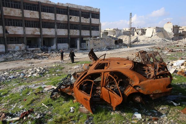 كيفا جاويش وزوجها تاج الدين أحمد يسيران وسط ركام في أحد شوارع حي الحيدرية، وهذه زيارتهما الأولى للمكان منذ أربعة أعوام، 4 ديسمبر/ كانون الأول 2016 - سبوتنيك عربي