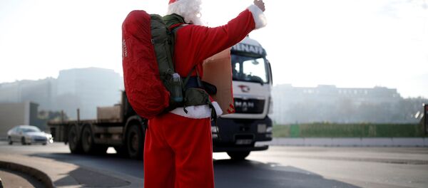 رجل فرنسي (كابتن ريمي) يرتدي زي بابا نويل خلال رحلته في باريس، فرنسا ديسمبر/ كانون الأول 2016 - سبوتنيك عربي