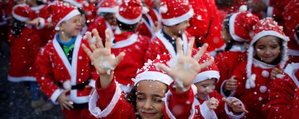 أطفال يرتدون زي سانتا كلاوز (بابا نويل) للمشاركة في إحدى أكبر المسيرات الخيرية وذلك لجمع الطعام للمحتاجين في لشبونة، البرتغال 12 ديسمبر/ كانون الأول 2016 - سبوتنيك عربي