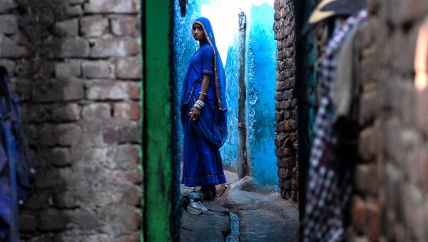 امرأة هندية تسير بجوار منزلها في نيو دلهي، الهند 20 ديسمبر/ كانون الأول 2016 - سبوتنيك عربي
