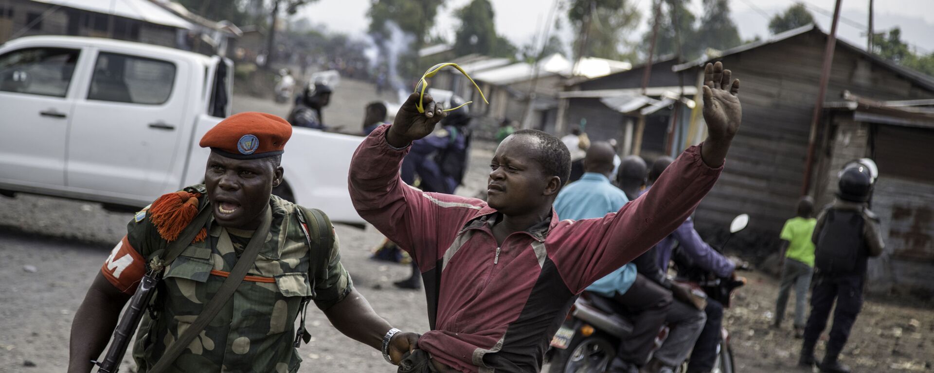 ضابط يلقي القبض على رجل حاول إغلاق الطريق بالحجارة، في حي ماجينغو في غوما، شرق جمهورية الكونغو الديمقراطية، في 19 ديسمبر/ كانون الأول عام 2016، - سبوتنيك عربي, 1920, 30.11.2021