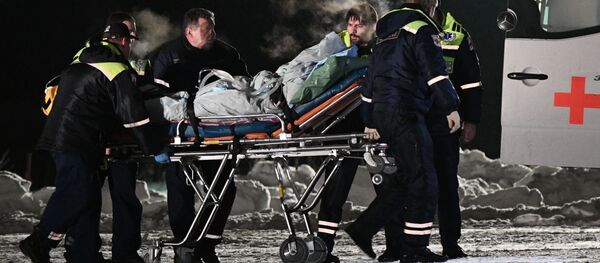 عناصر من الفريق الطبي التايع لوزارة الطوارئ الروسية يقومون بإخراج أطفال من طائرة _تابعة لوزارة الطوارئ) الذين تم إيصالهم إلى مستشفيات موسكو بعد تعرضهم لحادث سير في خانتي-مانتيسك - سبوتنيك عربي