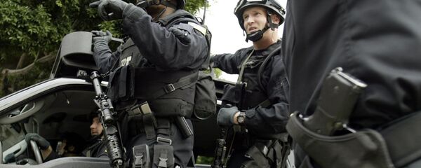 FBI agents in riot gear get information from a Los Angeles Police Department police officer (R) as they head towards the Mexican consulate in Los Angeles - سبوتنيك عربي