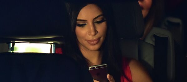 US reality TV star Kim Kardashian looks at her iPhone as she sits in a car after visiting the genocide memorial, which commemorates the 1915 mass killing of Armenians in the Ottoman Empire, in Yerevan on April 10, 2015 US reality TV star Kim Kardashian looks at her iPhone as she sits in a car after visiting the genocide memorial, which commemorates the 1915 mass killing of Armenians in the Ottoman Empire, in Yerevan on April 10, 2015 - سبوتنيك عربي