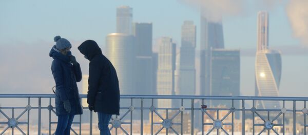 شخصان يقفان على خلفية ناطحات سحاب لـ موسكو سيتي، ودرجة الحرارة 27 درجة مئوية تحت الصفر. - سبوتنيك عربي