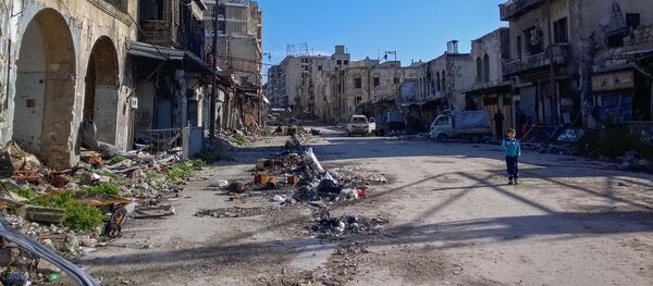 صبي يسير في شارع بحي الناظرية في حلب، سوريا - سبوتنيك عربي