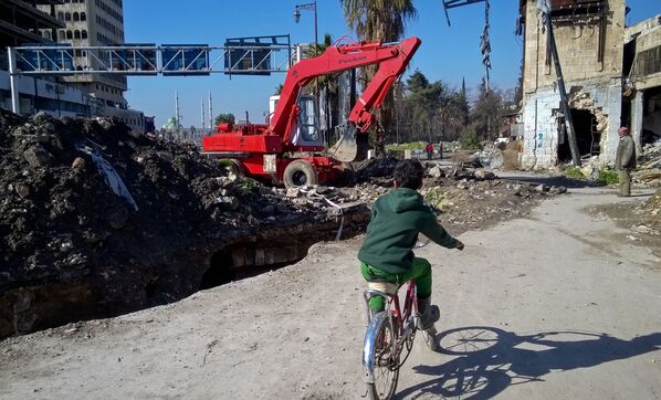 صبي يسير في شارع بحي الناظرية في حلب، سوريا - سبوتنيك عربي