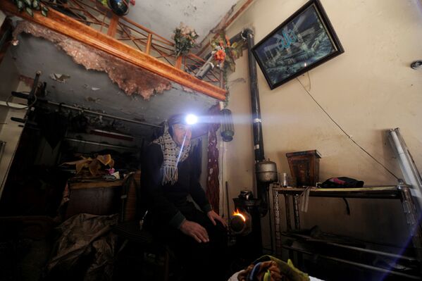 رجل يجلس بجوار نار للتدفئة في حلب، سوريا 30 يناير/ كانون الثاني 2017 - سبوتنيك عربي