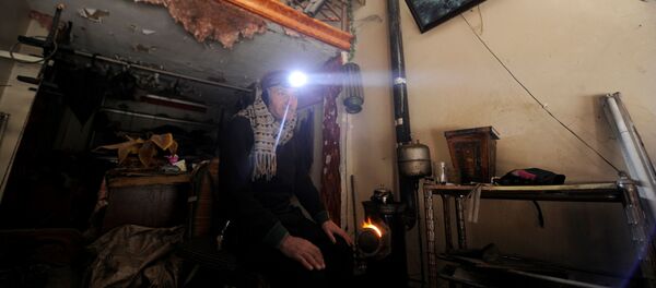 رجل يجلس بجوار نار للتدفئة في حلب، سوريا 30 يناير/ كانون الثاني 2017 - سبوتنيك عربي